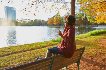 Woman listening music in the autumn park