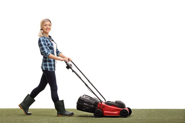 Woman mowing a lawn with a lawnmower