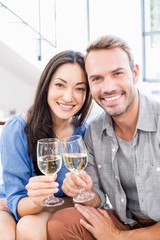 Young couple toasting wine glasses