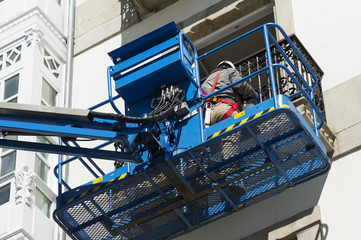 construction  workers in bucket of  crane vehicle for restore the old  building
