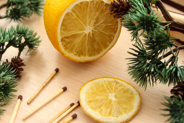Obraz na płótnie Canvas Flat lay of yellow objects for your diet such as sliced lemon, matchsticks, surrounded by green pine branches.