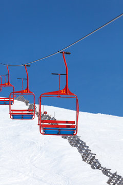four red chairs of ski lift