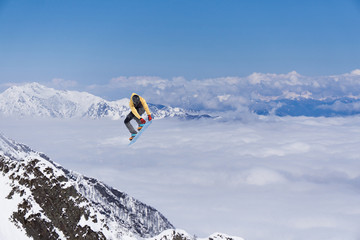 Snowboard rider jumping on mountains. Extreme snowboard freeride sport.