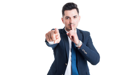 Confident businessman making keep a secret and silence gesture