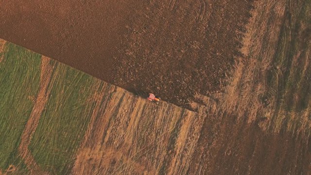 aerial video of tractor plowing a field