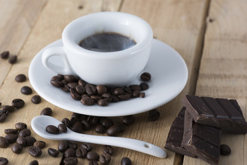hot espresso coffee in a white cup served on an old wooden table.