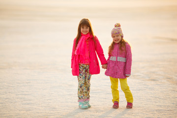 little girls sisters hugging and holding hands in nature. childr