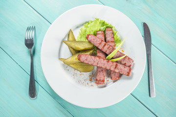 hunting sausage of beef with pickled cucumber Top view with copy