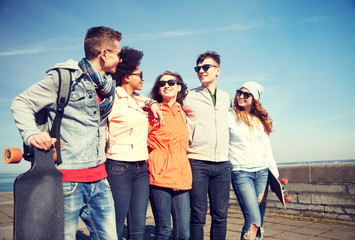 Naklejka premium happy teenage friends with longboards on street
