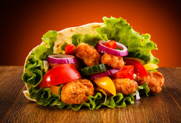 Chicken nuggets and vegetables in tortilla wrap