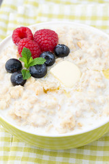 Oatmeal porridge in bowl with berries raspberries and blackberri