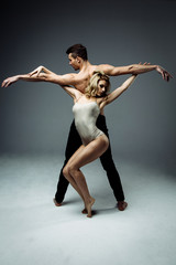 Flexible young modern acrobats couple posing in studio. Fashion portrait of attractive dancing...