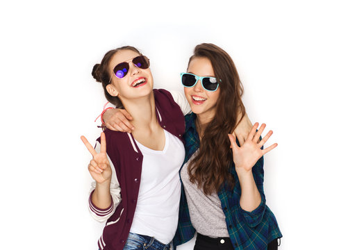 smiling teenage girls in sunglasses showing peace