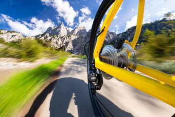rear view of fast moving yellow bicycle mountain bike in front of mountains / mountainbike fahrrad...