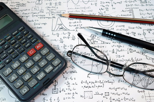 Eye Glasses, pen and pencil over the Formula with calculator - Powered by Adobe