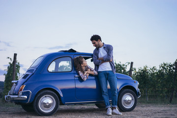 Young couple doing a road trip in Tuscany countryside in a vintage car - 108719829