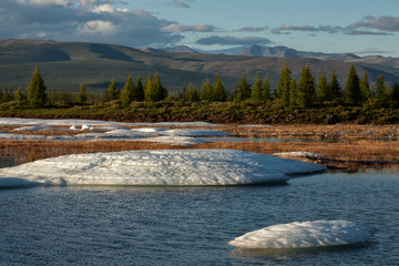 Remains of the ice in the river valley after the winter. Moma River. Yakutia. Russia.