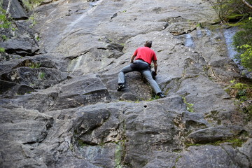 Mann klettert auf Felswand