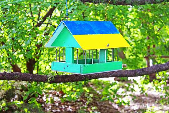 Bird feeder painted as Ukrainian flag in the summer forest
