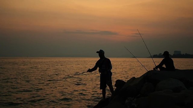 fisherman fishing, silhouette in sunset.

