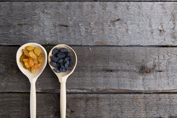 Tasty small raisins on a wooden spoon