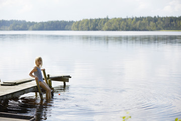 Portrait of girl on wooden ladder at dock
