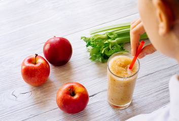 Woman drinking a smoothie of apples and celery in the morning, v