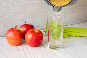 Smoothies made from apples and celery poured into a glass