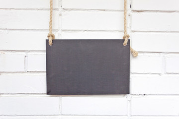 poster hanging on a rope and brick wall