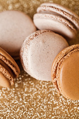 A french sweet delicacy, macaroons vanilla and caramel on gold b