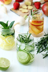 salutare acqua con frutta e erbe in vasetti di vetro