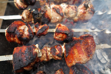 Pork shashlyk (shish kebab) roasting on skewers in the garden