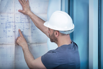 Architect builder studying layout plan of the room