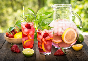 Pink lemonade with lemon, lime and strawberries 