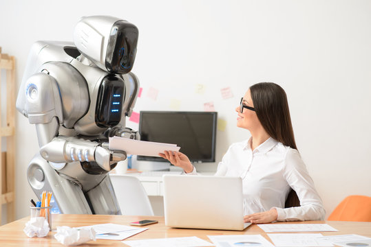Nice girl and robot working in the office 