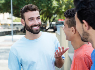 Mann mit Bart spricht mit Freunden in der Stadt