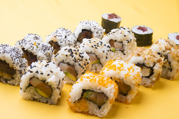 Various kinds of sushi food served on yellow blackground