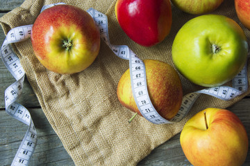 Apples with tape measure, Open notebook for notes. The concept of a healthy lifestyle and losing weight. Free space for text. Copy space. selective soft focus