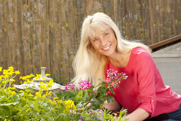 Frau mittleren Alters im Garten bei der Gartenarbeit