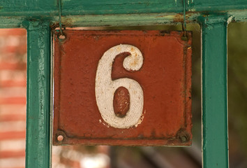 Old retro weathered cast iron plate with number 6