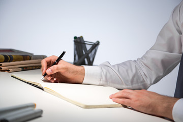 Businessman writing in journal side