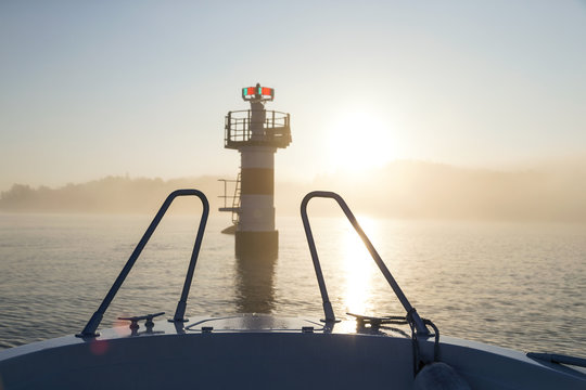 Boat approaching tower on lake at sunrise
