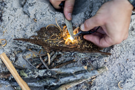 Man lighting fire on beach