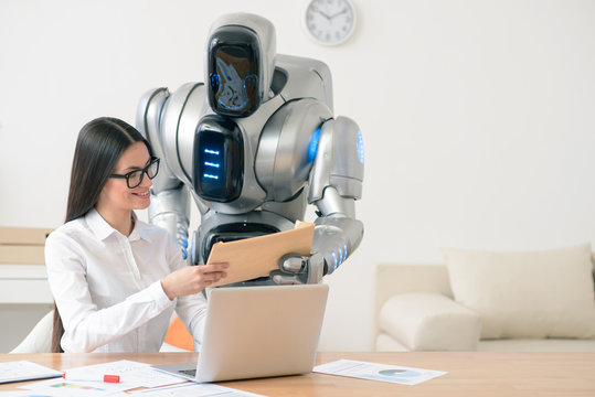 Positive smiling girl getting package from the robot