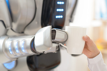 Nice robot  giving cup of coffee to a girl