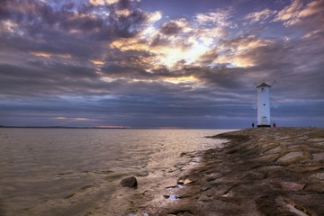 Fototapeta na wymiar Lighthouse windmill Stawa Mlyny in Swinoujscie, Baltic Sea, Poland.