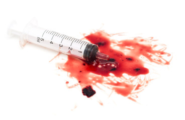 syringe and red blood on white background