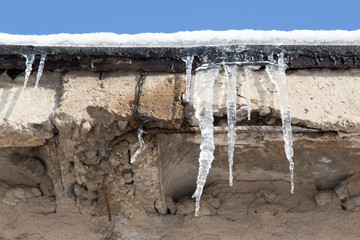 icicles on a roof of a house in winter