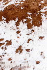 snow on red clay in nature