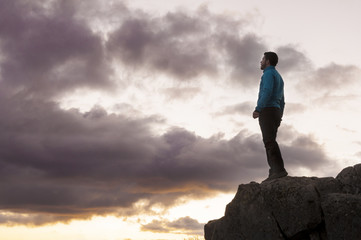 Victorious man contemplates the sunset
